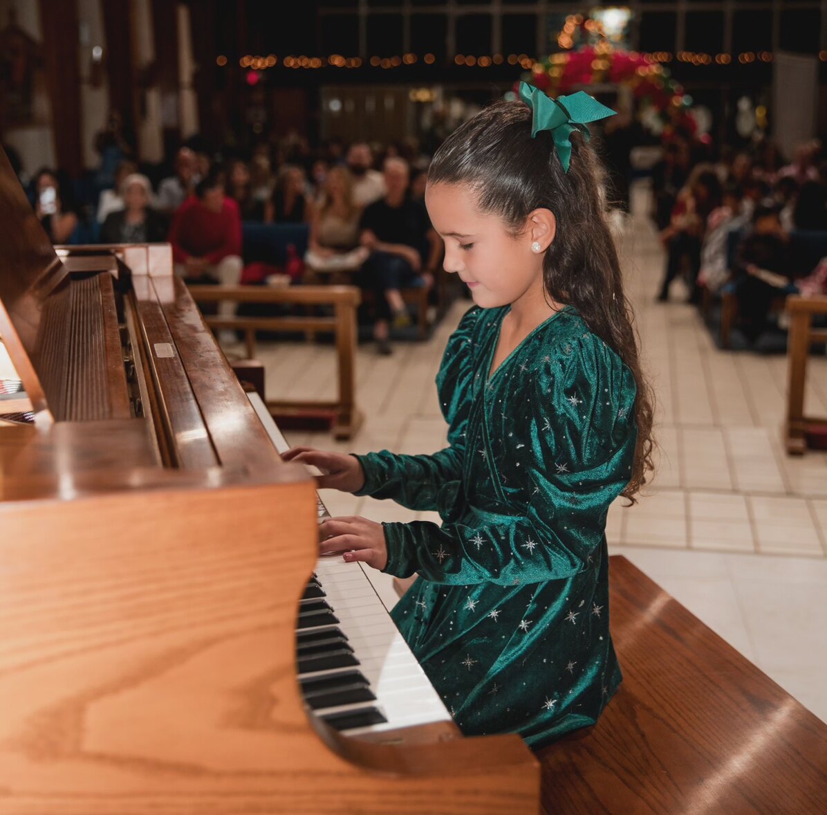 A young student playing piano at a recital